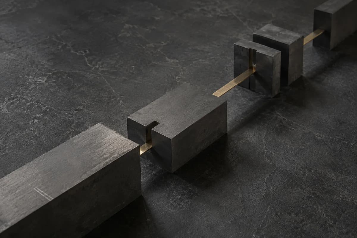 A thin brass strip passing through precisely cut graphite blocks